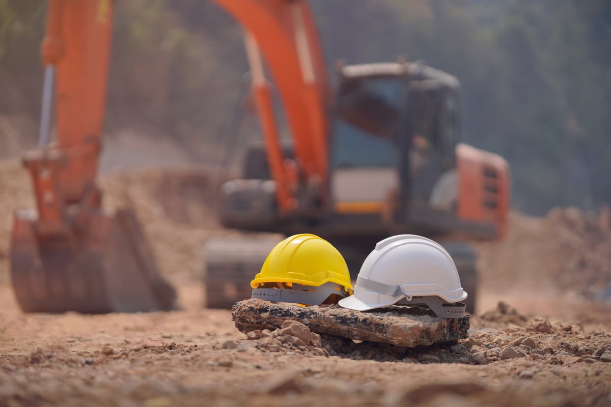 Safety helmet at construction site, road construction site background, safety concept